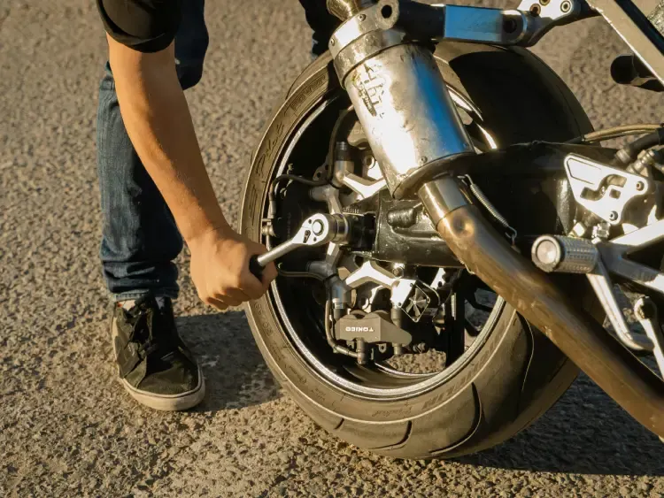 Persona comprobando la presión de un neumático de moto